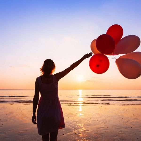 imagination and creativity, girl with multicolored balloons at sunset with copyspace, inspiration concept